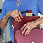Person holding a red handbag with jewelry on
